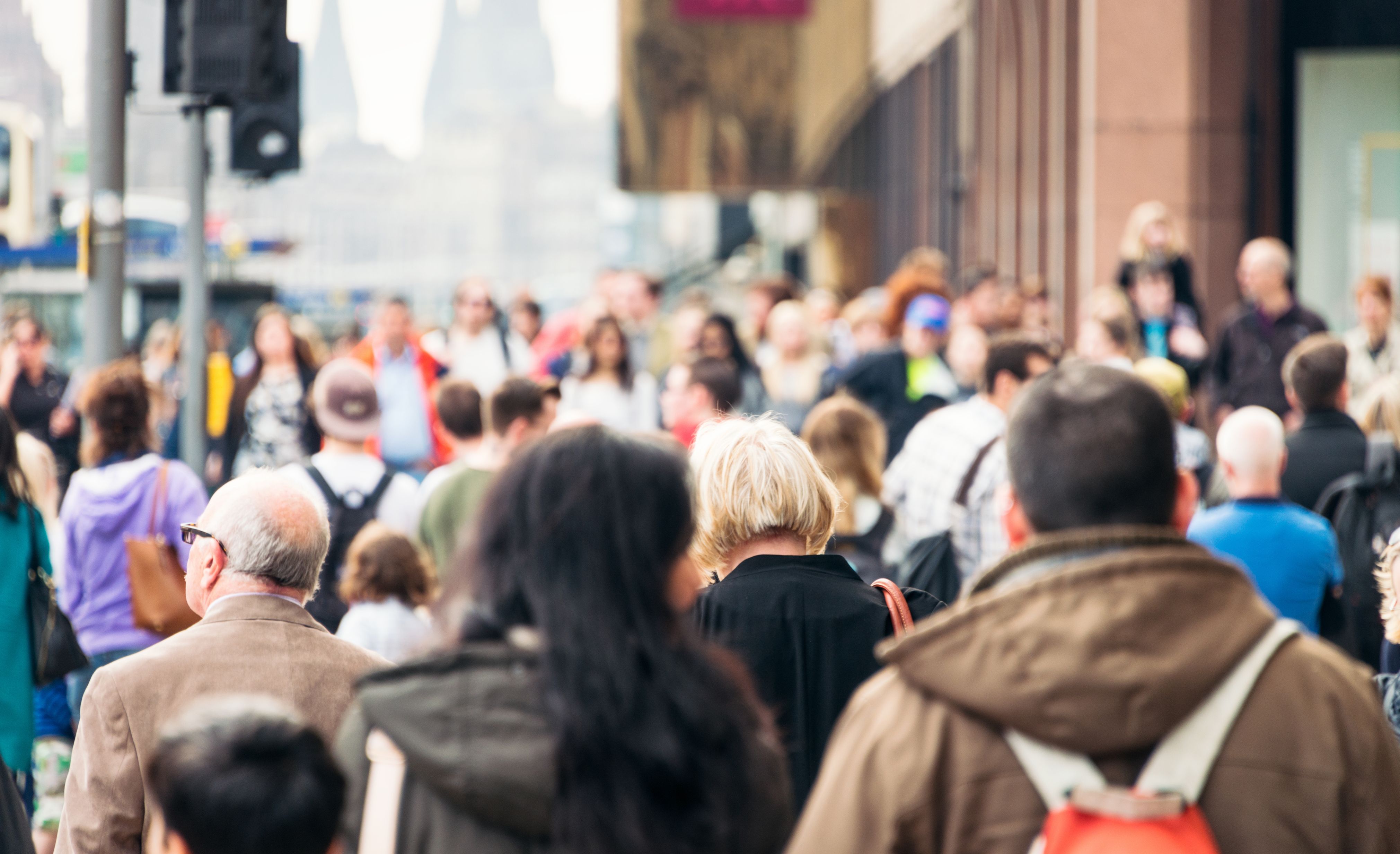 A crowd of people walking along a busy high street in Edinburgh, Scotland.