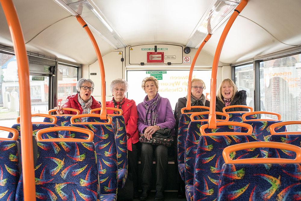 Five elderly women sat at the back of a bus