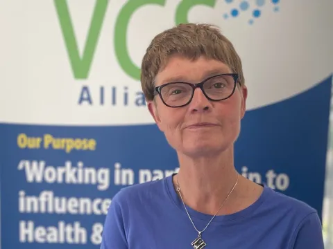 Sam Keighley head and shoulders in front of a banner for the VCS Alliance