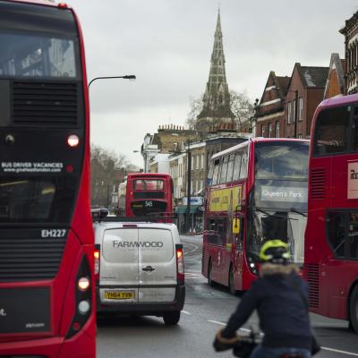 Buses, private vehicles and cyclists showing mixed transport use on a road