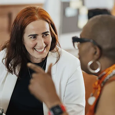 Two women in business wear have an animated discussion