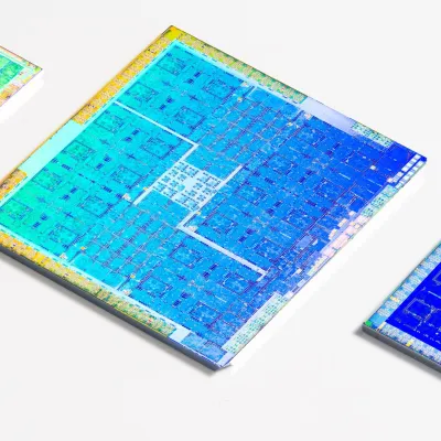 Three colorful GPUs with their packaging cleanly removed laying on a white surface 