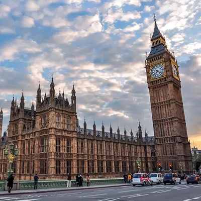 Image of the Palace of Westminster and Queen Elizabeth Tower against a bright cloudy sky.
